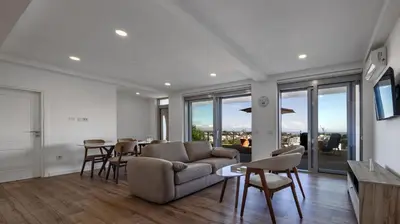 a living room with a couch and a table with chairs at Gjerana SEAVIEW in Ulcinj