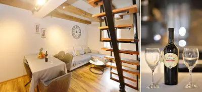 a room with a bottle of wine and a table with wine glasses at Antica Apartments in Kotor