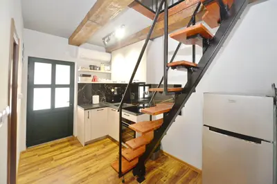 a kitchen with a spiral staircase in a kitchen with a refrigerator at Antica Apartments in Kotor