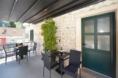 a patio with a table and chairs and a door at Antica Apartments in Kotor