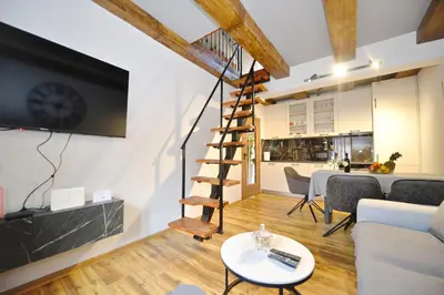 a living room with a staircase and a dining room at Antica Apartments in Kotor