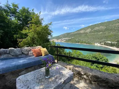 a bench with a view of a body of water at Stone & Sea house in Valdanos