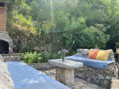 a couch sitting on a stone bench in a garden at Stone & Sea house in Valdanos