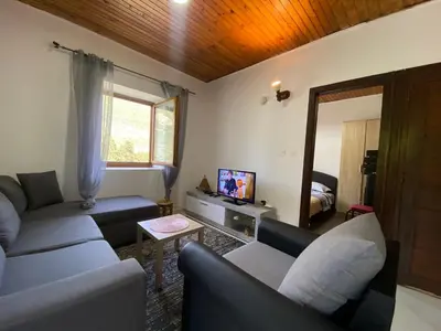 a living room with a couch and a tv at Stone & Sea house in Valdanos