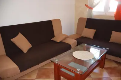 a living room with two couches and a coffee table at Apartmani Mulic in Sutomore