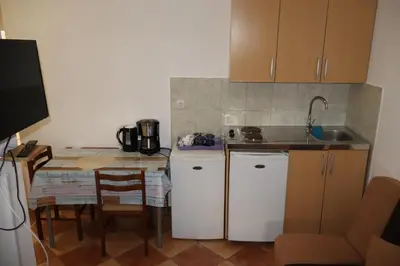 a small kitchen with a table and a counter top at Apartmani Mulic in Sutomore