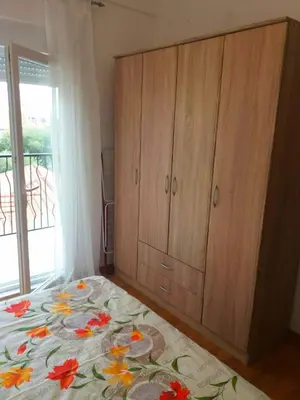 a bedroom with a bed and a wooden cabinet at Cosy 1 bedroom apartment BUDVA in Budva