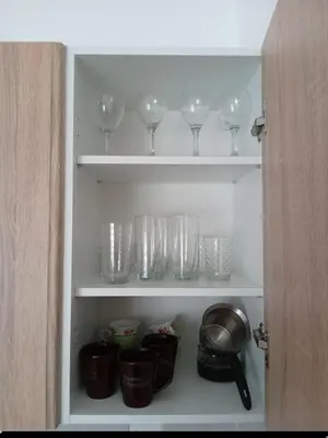 a cupboard with wine glasses and other items in it at Cosy 1 bedroom apartment BUDVA in Budva