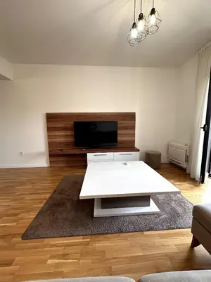 a living room with a white table and a flat screen tv at Where Comfort Meets Convenience! in Stara Varoš