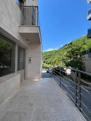 a walkway leading to a building with a hill in the background at Apartment Montenegro Becici in Becici