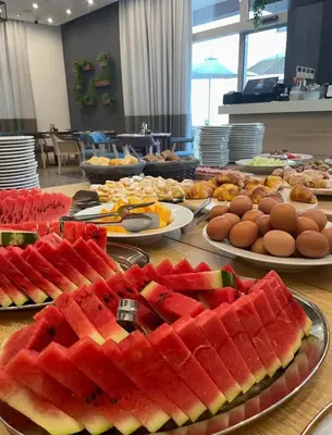 a table with many plates of watermelons and eggs at Apartment Montenegro Becici in Becici