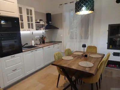 a kitchen with a wooden table and chairs and a kitchen with white cabinets at Giardino in Muo