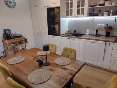 a kitchen with a wooden table with chairs and a kitchen counter at Giardino in Muo