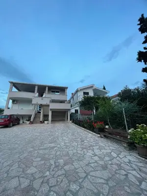 a house with a stone driveway in front of it at Belaapartman in Kravlja