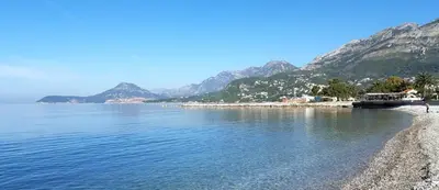 a beach next to the water with mountains in the background at Sal y Sol in Bar