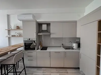 a kitchen with white cabinets and a table and chairs at Sal y Sol in Bar