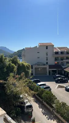 a parking lot with cars parked in front of a building at Montenegro Seaside Lux Apartment in Petrovac na Moru