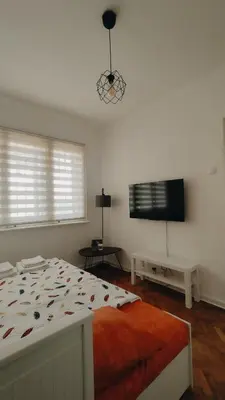 a bedroom with a bed and a flat screen tv at Cozy & Bright Garden Flat in Podgorica