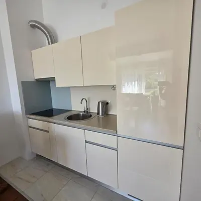a kitchen with white cabinets and a sink at Summer vacation near Sveti Stefan in Podličak