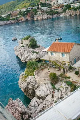 a house on the side of a cliff in the water at Summer vacation near Sveti Stefan in Podličak