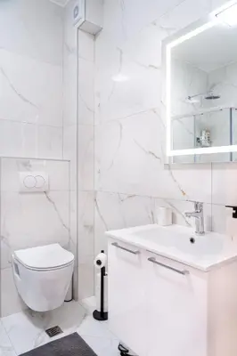a white bathroom with a toilet and a sink at Apartment BAR M3B in Bar