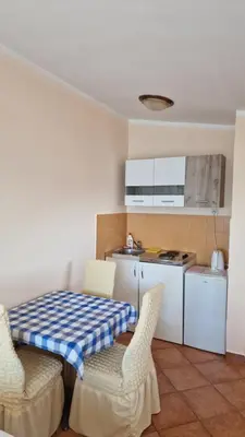 a kitchen with a table and chairs in a room at Apartmani Orange Dreams in Sutomore