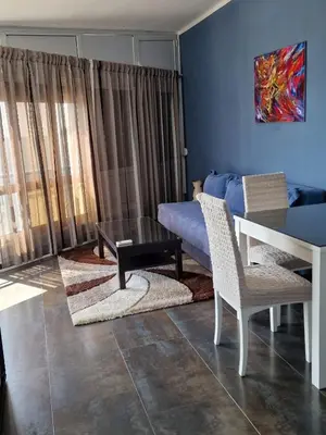 a living room with a bed and a table and chairs at Apartmani Orange Dreams in Sutomore