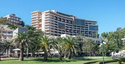 a large building with palm trees in a park at Harmonia Apart Hotel in Boreti
