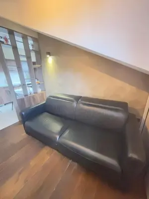 a black leather couch sitting in a room at Loft Suite in Budva