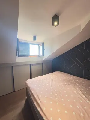 a bedroom with a bed and a window at Loft Suite in Budva