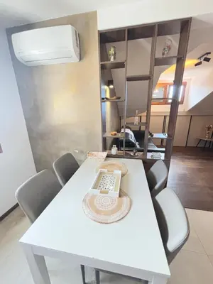 a white dining room table with a hat on it at Loft Suite in Budva