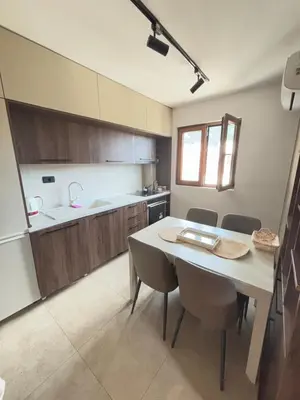 a kitchen with a table and chairs in a room at Loft Suite in Budva