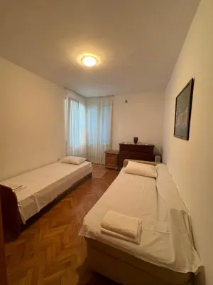 a bedroom with two beds and a window at Apartman OLIVA3 in Petrovac na Moru