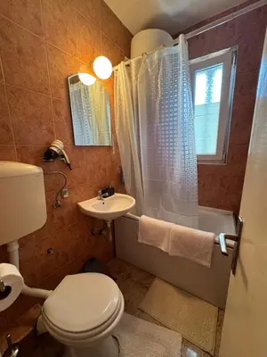 a bathroom with a toilet and a sink and a tub at Apartman OLIVA3 in Petrovac na Moru