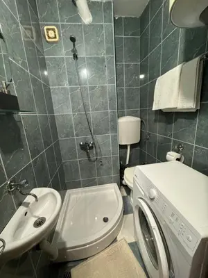 a bathroom with a white toilet and a sink at Apartman OLIVA3 in Petrovac na Moru