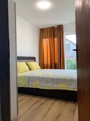 a bedroom with a bed with yellow pillows and a window at Utjeha house Ana in Utjeha