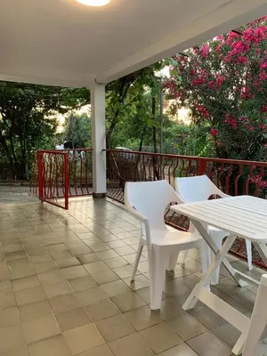 a porch with two white chairs and a table at Utjeha house Ana in Utjeha