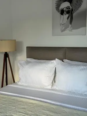 a bed with white pillows and a picture on the wall at Namai Apartments in Ulcinj