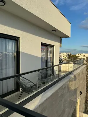a balcony with two chairs on a building at Namai Apartments in Ulcinj