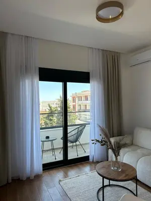 a living room with a couch and a view of a balcony at Namai Apartments in Ulcinj