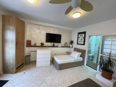 a living room with a bed and a flat screen tv at Apartman Sahat kula in Podgorica