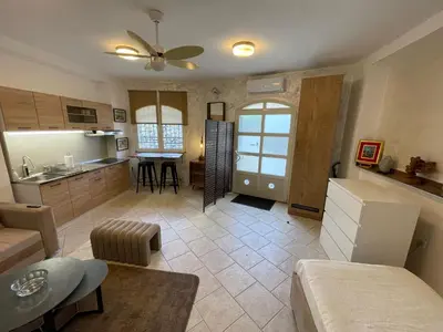 a kitchen and a living room with a table at Apartman Sahat kula in Podgorica
