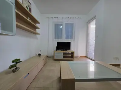 a living room with a table and a tv at Blue Dream Apartment in Rafailovici