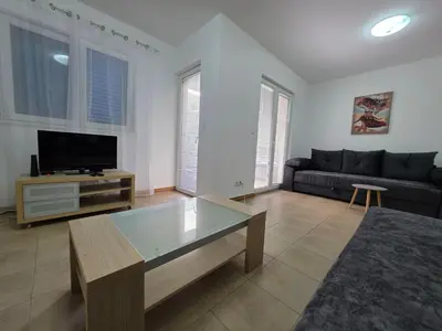 a living room with a couch and a tv at Blue Dream Apartment in Rafailovici