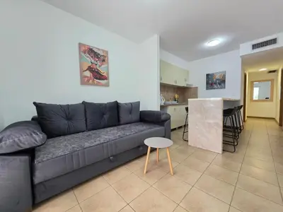 a living room with a couch and a kitchen at Blue Dream Apartment in Rafailovici