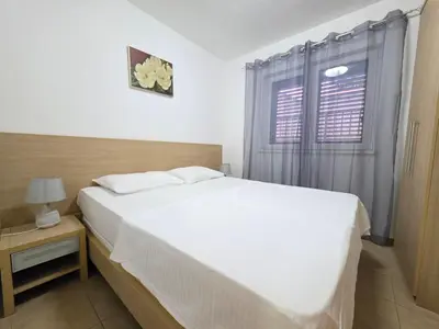 a bedroom with a white bed and a window at Blue Dream Apartment in Rafailovici