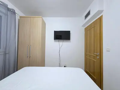 a bedroom with a bed and a tv on the wall at Blue Dream Apartment in Rafailovici