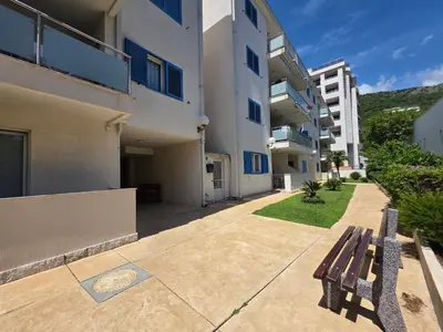 a bench sitting on a sidewalk next to a building at Blue Dream Apartment in Rafailovici