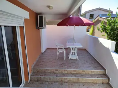 a table and chairs with an umbrella on a patio at Montana Mare in Sutomore