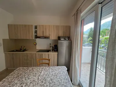 a kitchen with a table and a refrigerator and a window at Montana Mare in Sutomore